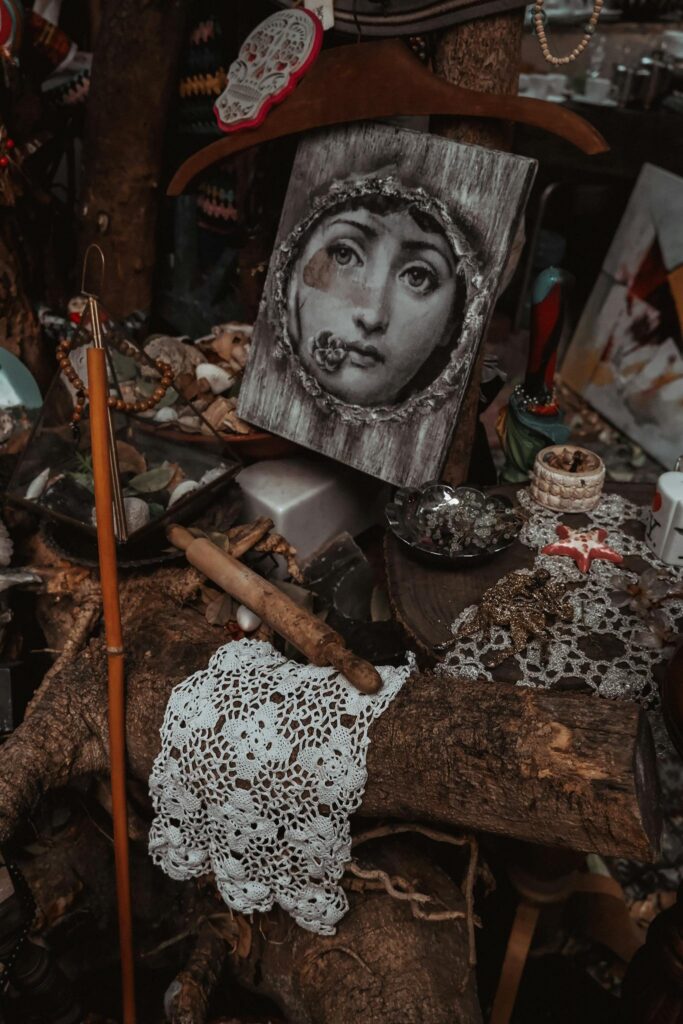 Intricate vintage portrait surrounded by handmade crafts and lace on a rustic wooden table.
